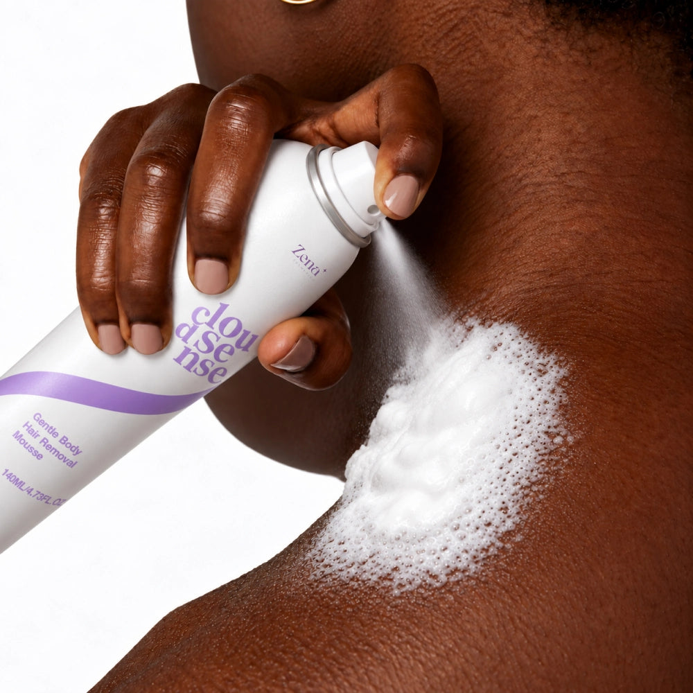 Close-up of a person holding a white and purple cloudisse foam removal canister and spraying white foam onto their neck against a white background.