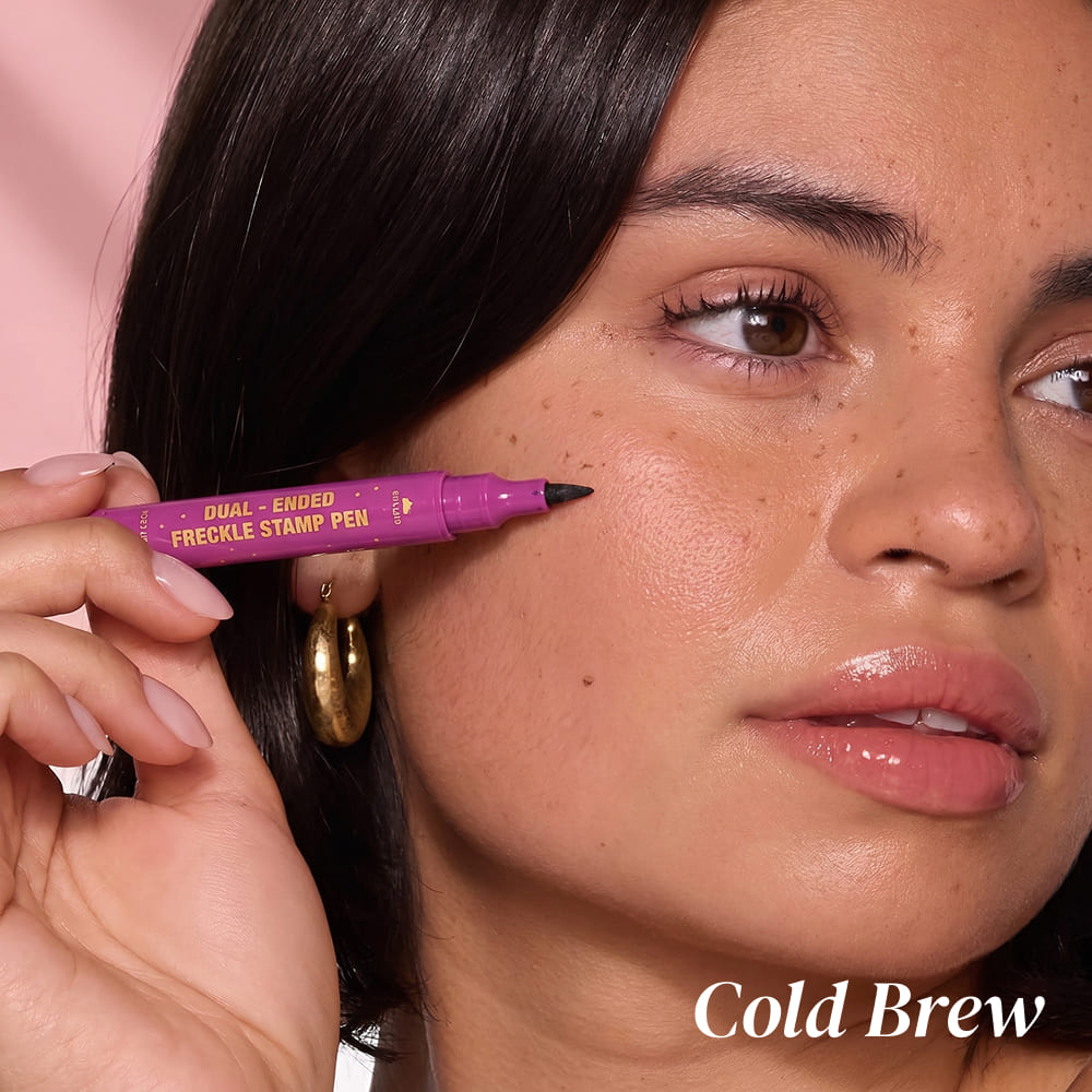 Woman holding a purple freckle stamp pen with 'Cold Brew' text