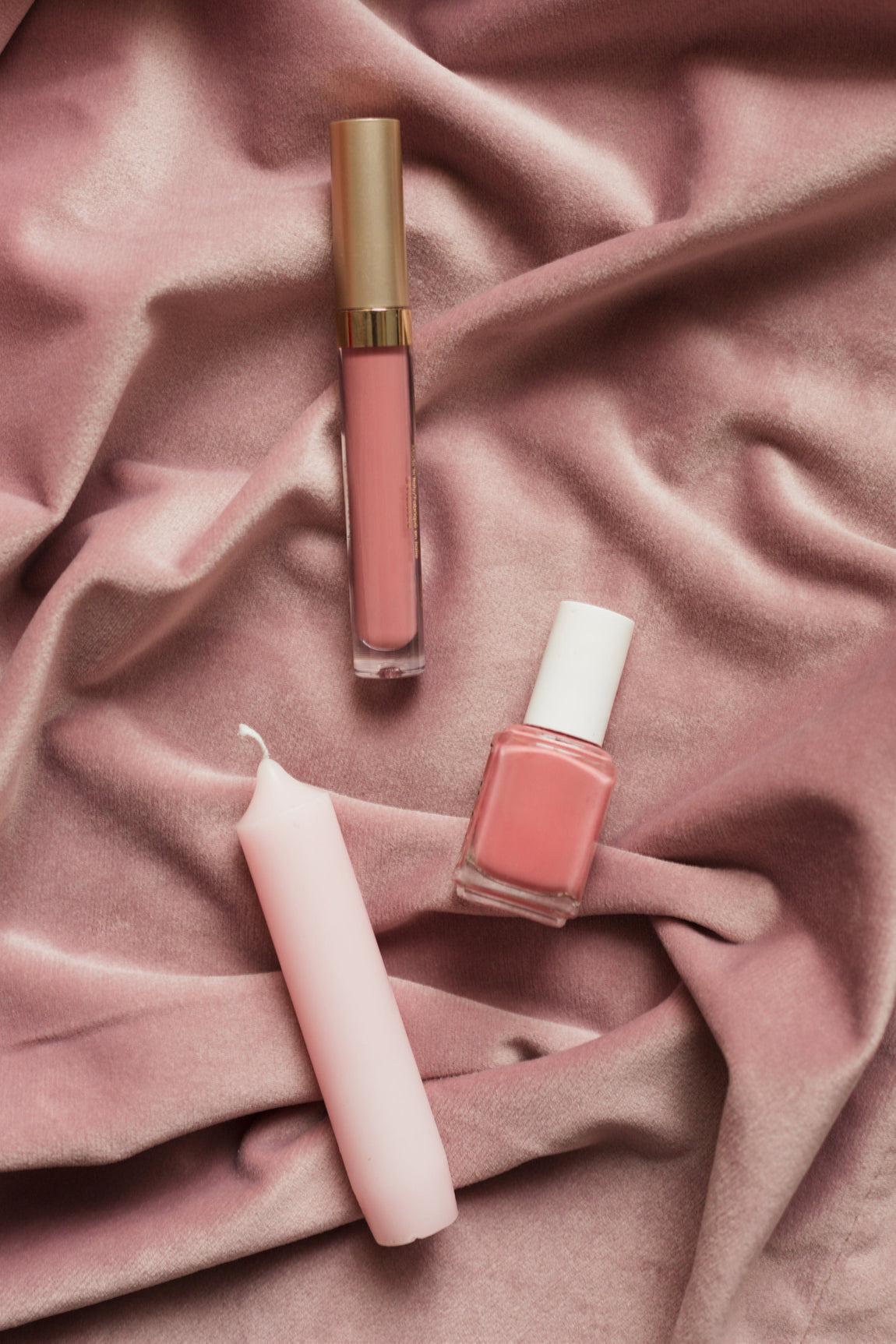 Blush makeup and candles on pink fabric