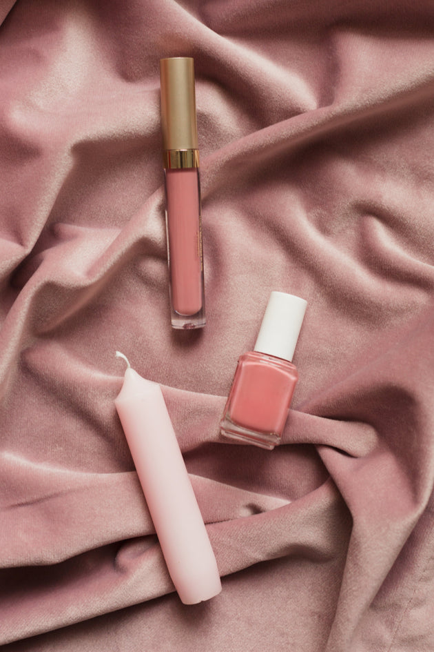 Blush makeup and candles on pink fabric