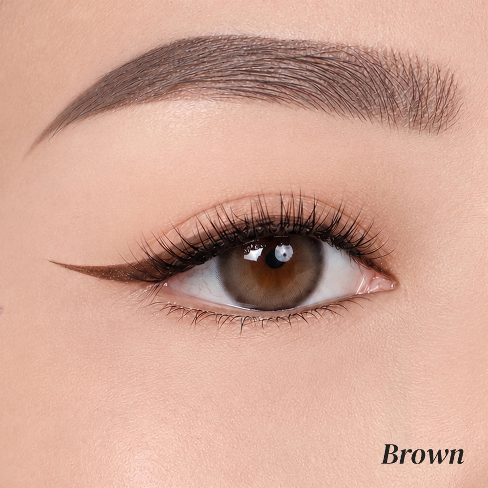 Close-up of a model's eye showcasing a brown winged eyeliner look, with a matching brown eyebrow and the word 'Brown' printed in the bottom right corner.